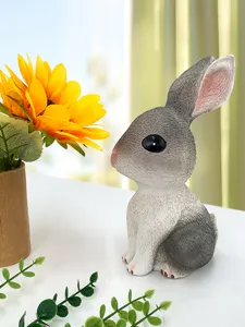 Schattig grijs konijn beeldje spaarpot voor paascadeau, mooie detailweergave van bureaudecoratie.