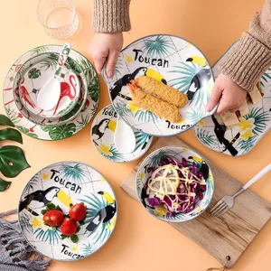 Detail van keramische toekan servies set met tropisch vogelpatroon voor eettafel decoratie.
