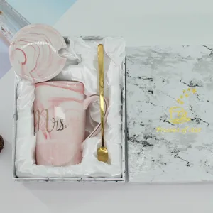 Nahaufnahme Detailansicht eines rosa Marmor Keramik Tassen Geschenksets mit goldenem Löffel.