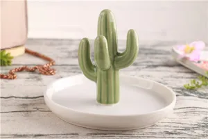 Detail van keramische cactus ringhouder met de groene cactusvorm en witte schaalbasis.