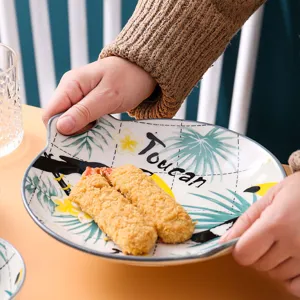 Keramisch bord met dubbele handgreep detail met tropisch toekan patroon en voedselweergave