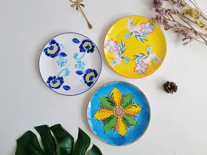 Hand-painted ceramic plate detail showing artistic floral patterns for home table setting.