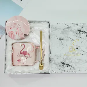 Detailansicht des rosa Marmor Keramik Tassen-Sets mit Deckel, Goldlöffel und Flamingo-Druck.