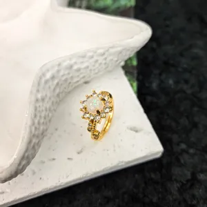 Bague ouverte dorée avec opale blanche et design de fleurs en zircon pour style chic.
