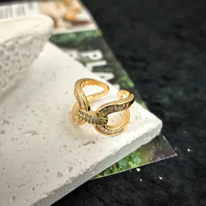 Bague ouverte dorée avec zircons étincelants dans un design croisé entrelacé chic et élégant détail.