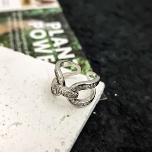 Bague ouverte croisée élégante en argent avec des détails étincelants en zircon.