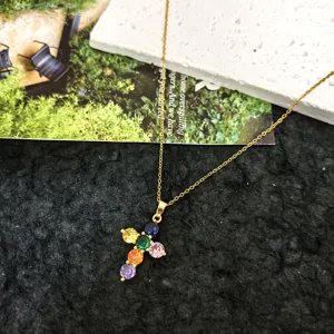Close-up detail of the colorful zirconia cross pendant necklace, elegant gold chain design.