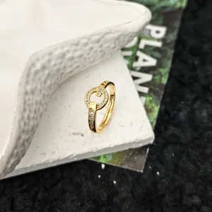 Gros plan détaillé de la bague ouverte dorée ornée de délicats cristaux scintillants.