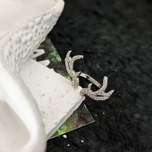 Gros plan détaillé de l'élégante bague ouverte en bois de cerf argenté, pavée de zirconiums.