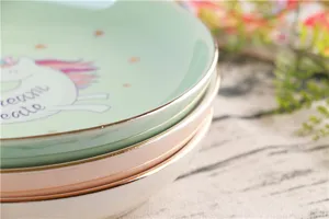 Leuke keramische dessertschaal met goudrand en eenhoorn patroon voor sieradenopslag en decoratie.