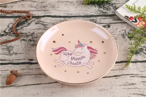 Leuke keramische schaal met gouden rand en eenhoorn patroon, ideaal voor sieraden en desserts.