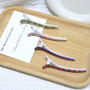 Detailed view of British style plaid duckbill hair clips, cute side fringe bobby pins.