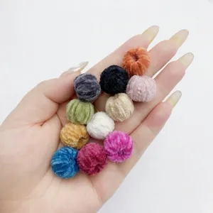 Detailed close-up of colorful velvet plush pom pom balls with piercing holes for DIY craft.