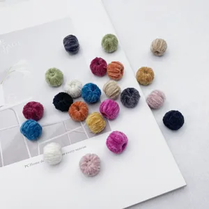 Close-up of colorful plush fuzzy round beads with perforation for DIY jewelry crafts.