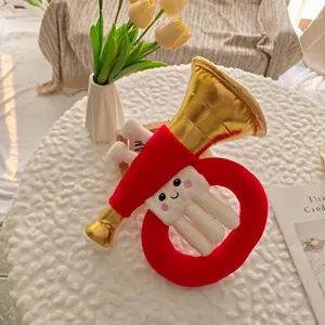 Gros plan sur le jouet trompette en peluche créatif, visage brodé mignon, tissu doux texture.