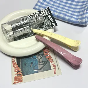 Detailed view of chic crackle texture duckbill hair clips in charming pastel yellow and pink.