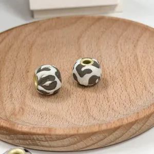 Detailed view of DIY handmade leopard print fabric beads with metal core for jewelry crafts.