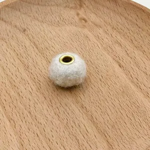Close-up detail of fluffy plush metal eyelet bead for DIY phone chains and bag accessories.