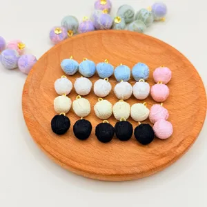 Detail view of colorful fabric covered spherical beads with metal loop for DIY jewelry craft.