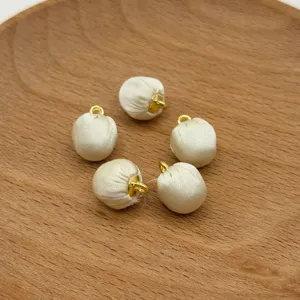 Fabric wrapped ball buttons with gold loops, detail view of DIY jewelry accessories.