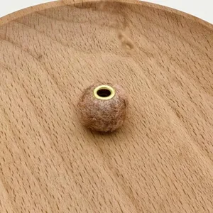 Handmade fuzzy felt ball bead with gold metal eyelet for DIY phone charms jewelry making.