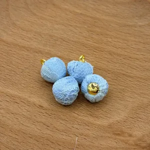 Close-up detail of light blue lace fabric covered buttons beads for handmade DIY jewelry.