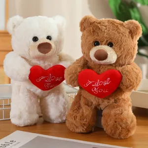 Vista dettagliata di simpatici orsacchiotti di peluche di coppia con cuscini rossi ricamati.