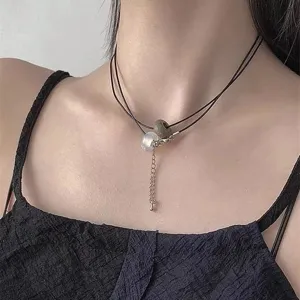 Close-up van de meerlaagse zwarte koord choker ketting met jade kralen en opaal hanger.