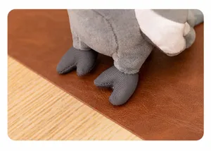 Primer plano detallado de los pies de loro de peluche gris, textura suave y diseño tierno.