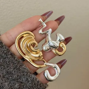 Gold and silver two-tone abstract geometric earrings, asymmetrical design, avant-garde style.