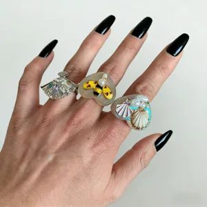 Détail de bagues statement en résine faites à la main, bijoux tendance pour femmes.