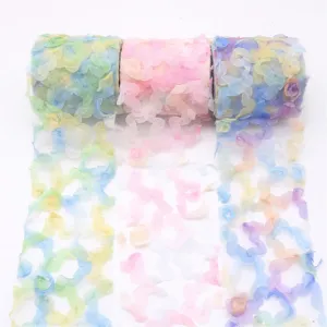 Vue détaillée de rouleaux de ruban tulle floral dégradé coloré pour bricolage et nœuds.
