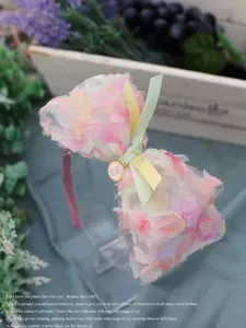 Serre-tête artisanal en tulle dégradé avec nœud en ruban et détail de pendentif métal.