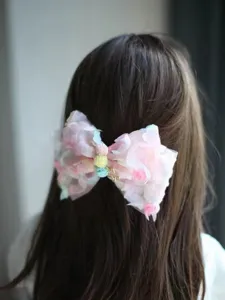 Vue détaillée du superbe nœud de cheveux en résille florale rose avec de délicats pétales.
