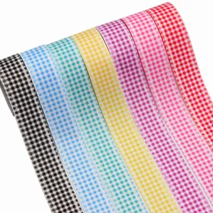 Vista dettagliata di rotoli di nastro grosgrain colorato a quadri con bordi di zampe carine.