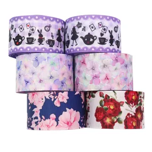 Close-up detail of printed grosgrain ribbon rolls featuring floral and fairy tale motifs.