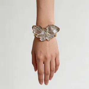 Close-up detail of the elegant pearlescent butterfly cuff bracelet worn gracefully on wrist.