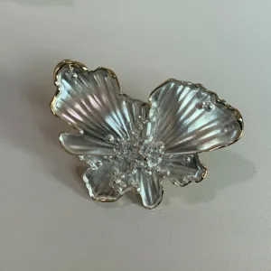 Designer style pearlescent butterfly jewelry accessory, elegant metallic finish detail shot.