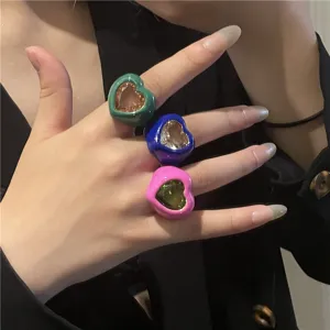 Gros plan sur des bagues cœur en émail coloré chunky avec grande pierre précieuse pour le style.