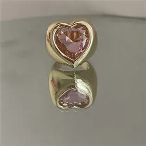Gros plan détaillé d'une bague dorée épaisse ornée d'une grande pierre précieuse en cristal rose.