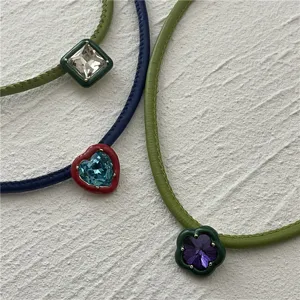 Detail view of trendy PU leather crystal choker necklace with cute colorful crystal pendants.