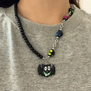 Halloween asymmetrische zwarte kralenketting met schattige cartoon vleermuis hanger.