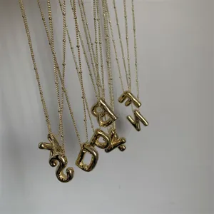 Gouden 3D letter hanger ketting detailweergave met fijne kralenketting en glanzende afwerking.