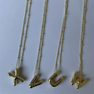 Gouden puffer letter hanger ketting detail, met stijlvolle massieve beginletter bedels aan ketting.