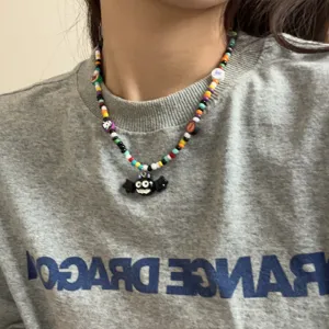 Detailopname van een kleurrijke handgemaakte kralenketting met schattige vleermuishanger.