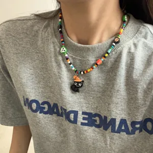 Detailopname van een kleurrijke handgemaakte kralenketting met zwarte kattenhanger.