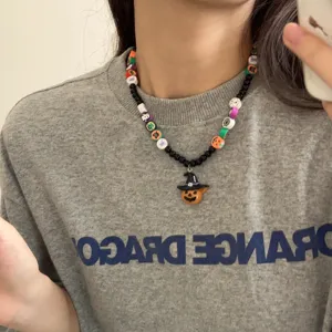 Detailopname van een Halloween kralenketting met een schattige pompoen hanger en kralen.