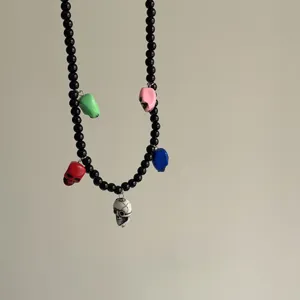 Gedetailleerd overzicht van een zwarte kralenketting met kleurrijke schedelbedeltjes.