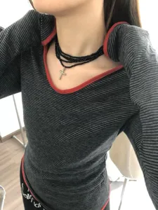 Collier ras de cou multicouche de perles noires avec pendentif croix argentée gros plan chic.