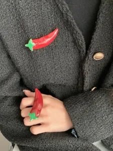Red enamel chili pepper brooch and ring detailed view, sweet cool dopamine style jewelry design.